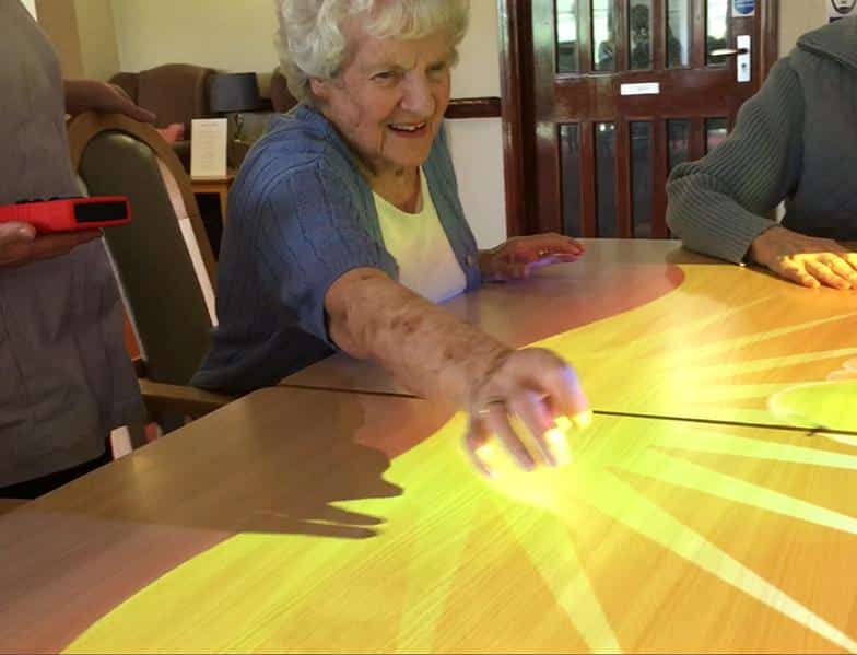 woman reaching to touch omi projection on table