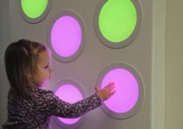 Girl playing with touch sound light wall panel