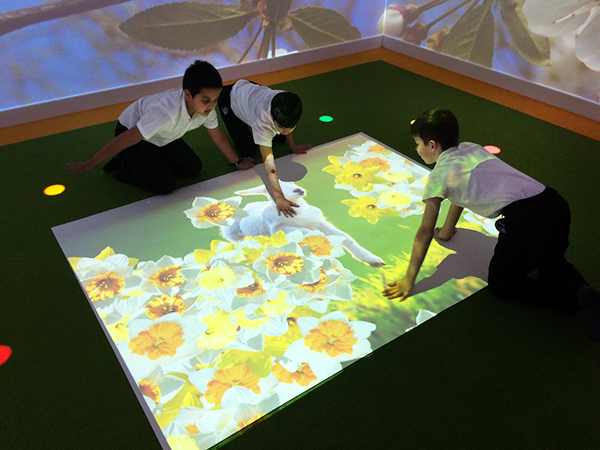 3 boys playing on floor with omi's motion-activated projection