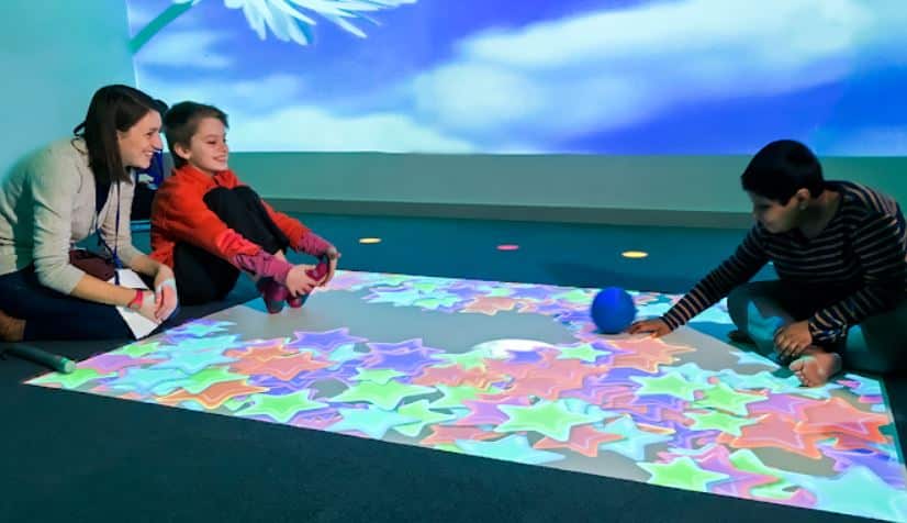 Children playing in sensory room with interactive projector