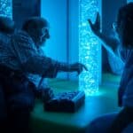 Elderly man with dementia with nurse in sensory room with bubble tube