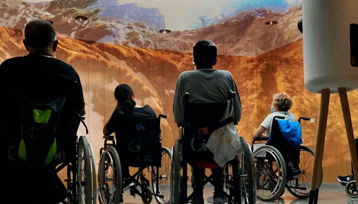 Wheelchair users exploring mountains with VR projector